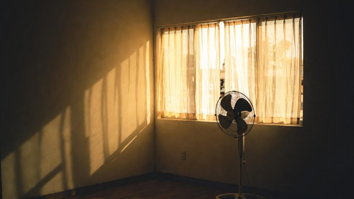 Cosa succede al corpo quando il caldo non concede pause 1 Stanza con ventilatore e tende socchiuse durante un'ondata di calore