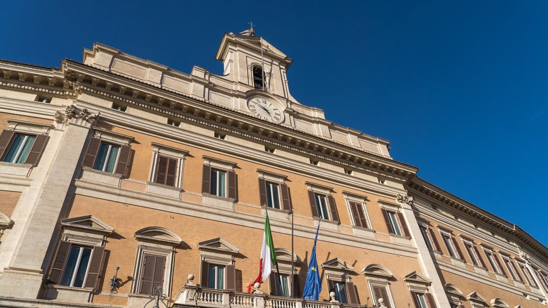 Facciata di Palazzo Montecitorio a Roma con orologio e bandiere, sede della Camera dove è stato restituito l'anello trovato in bagno da Simonetta Matone