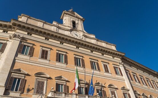 Facciata di Palazzo Montecitorio a Roma con orologio e bandiere, sede della Camera dove è stato restituito l'anello trovato in bagno da Simonetta Matone