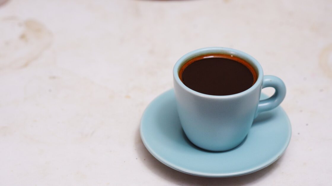 L-teanina nel caffè: una tazzina di espresso su un piattino azzurro, foto di repertorio
