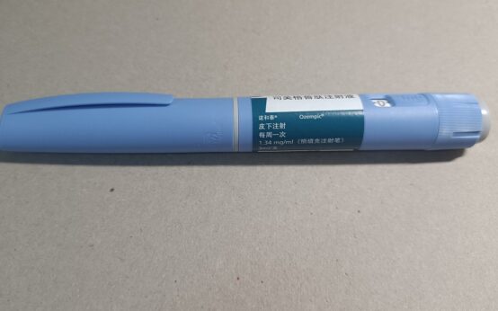 Una penna preriempita di Ozempic (semaglutide) da 3 ml con etichetta in cinese appoggiata su un piano grigio